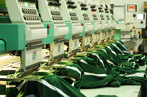 Embroidering custom sweatpants with customized logo for sport team clients.