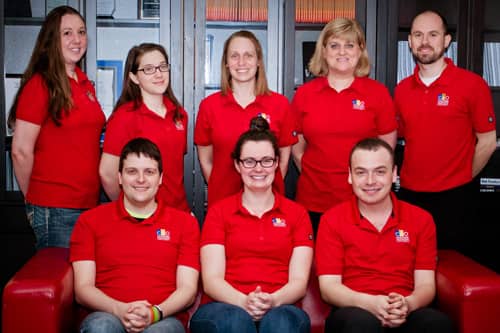 Employees wearing orange grocery store aprons, wearing custom uniforms.